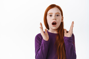 Impressed ginger girl with freckles gasping, clap hands and look amazed and astounded with...
