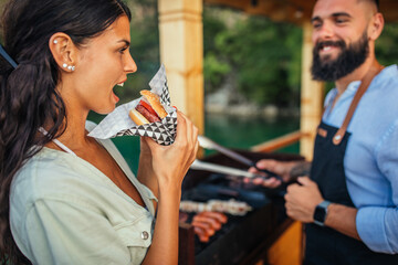 Young female tasting homemade burger