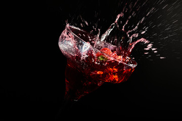 A strawberry dropping in a cocktail