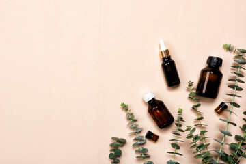 Glass brown bottles of essence or serum with natural eucalyptus leaves