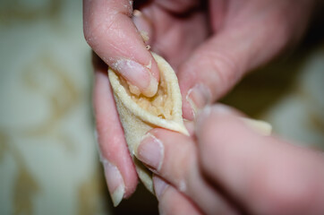 The girl sculpts dumplings with potatoes.