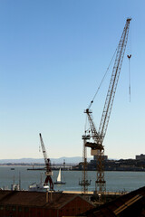 Fototapeta na wymiar Cranes working on the dock by the Tagus river