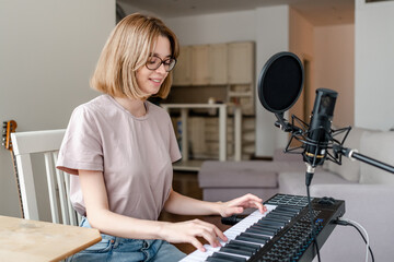 young woman playing piano at home
