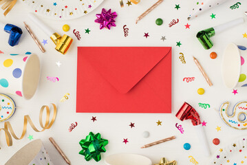 Above photo of red envelope cups confetti candles party whistle isolated on the white background