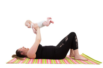 mother with baby having fun holding baby in the air while laying on a fitness mat