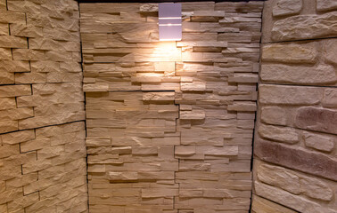 Background of stone walls with lighted lamp in dim yellow light