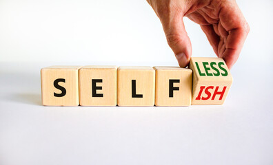 Selfish or selfless symbol. Businessman turns cubes and changes the word 'selfish' to 'selfless'....