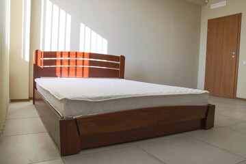 lacquered dark wooden bed with mattress