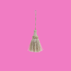 Golden silk tassel isolated on pink background for creating graphic concepts