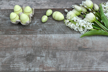 Tulpen und Hyazinthen mit Ostereiern auf Holzhintergrund