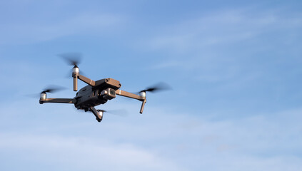 Drone or quadcopter in the sky at sunset.