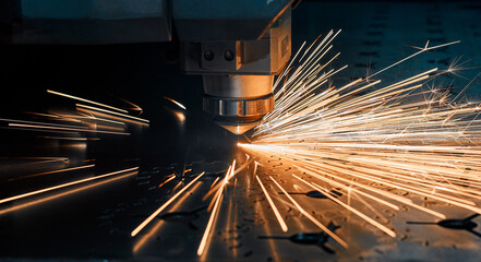 CNC machine. Laser cutting of metal. Modern industrial technologies. Close-up. Sparks fly