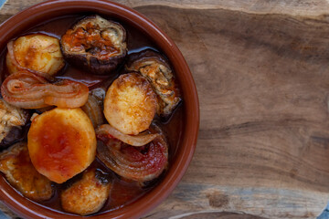 Various vegetables cooked in the oven in clay pot on wooden table