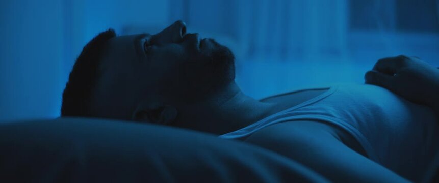 Close up of a soldier lying on bed, staring at the ceiling, dealing with post trauma.