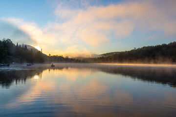 vue large d'un cygne gonflable qui flotte sur un lac super calme lors d'un lever de soleil enflammé