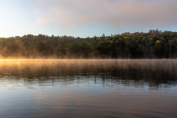 Obraz na płótnie Canvas brume matinale sur le lac au matin lors d'un lever de soleil belle symétrie