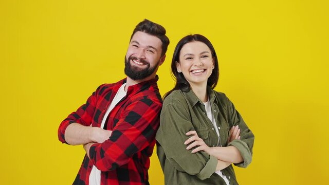 Portrait of happy young couple on yellow background, hitting fist on fist, gesture done, successful business and its completion, emotions of people