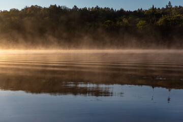 brume matinale sur le lac au matin lors d'un lever de soleil avec mouvement dans l'eau