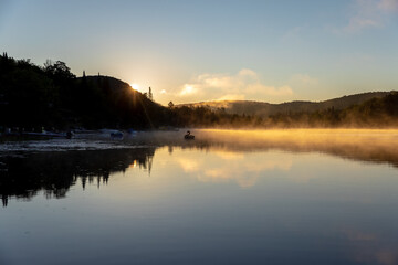 vue large d'un cygne gonflable qui flotte sur un lac calme lors d'un lever de soleil enflammé