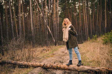 young beautiful woman in blue jeans walking outdoors in the forest