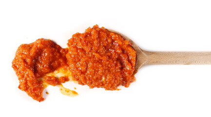 Roasted and cooked red paprika in wooden spoon isolated on white background, top view