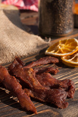 Organic pork jerky. Jerky for beer. Snacks. Dry lemon wedges in the background. Country style. 