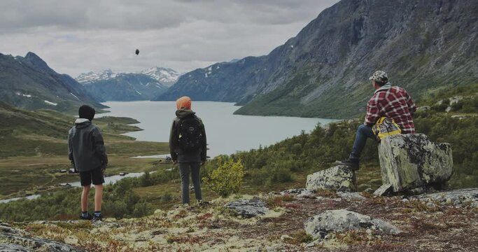 Father Watching Teenage Boys Throw Rocks On Hike