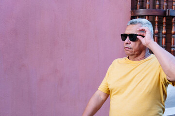 Older man wearing sunglasses and walking in the open air