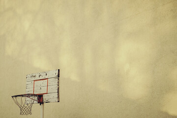 Fototapeta na wymiar Basketball hoop in the backyard on yellow wall with copy space
