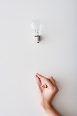 Female hand near an incandescent light bulb