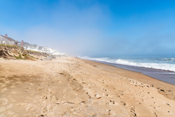 Beautiful sandy beach along the coast of New Hampshire on a foggy autumn morning