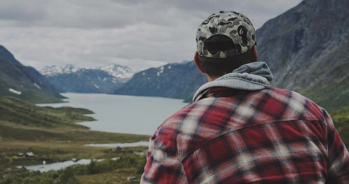 Man In Cap Looking At View Of Lake And Mountains