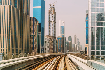 Fototapeta na wymiar Famous Dubai Metro railroad at skyscrapers buildings skyline background.