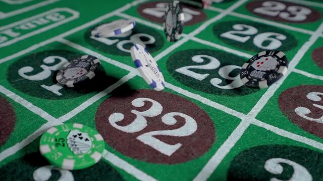 An extreme slow motion dolly slider shot of falling casino chips. Shot at 240fps. Chips are generic and don't represent any particular casino.  	