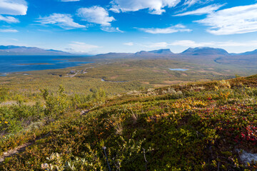Fototapeta na wymiar Lapponian gate, famous mountain pass in the Swedish arctic in beautiful autumn colors on a sunny day. Viewed from Nuolja, Njulla mountain. Hiking in Abisko national park, Kiruna, Sweden.
