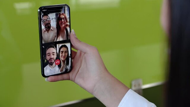 Detalle mano de mujer en videollamada con amigos