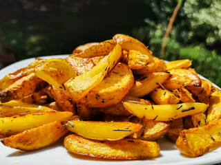 homemade baked Potatoe chips on a white plate in the garden
