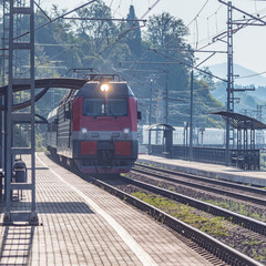Passenger train moves along Black sea coast. Sochi.