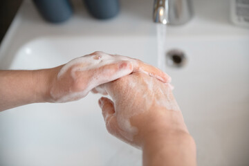 the girl washes her hands with a small, water flows from the tap