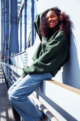 young cute teenage african girl in industrial zone happy smiling having fun, big city lifestyle...