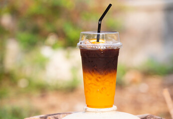 glass of orange and coffee with ice