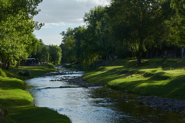 Fototapeta na wymiar river with contrasting sky and green nature