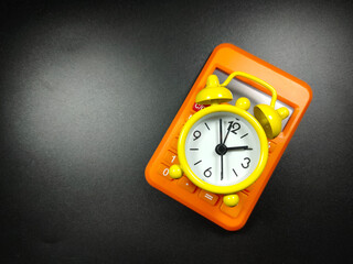 Selective focus of calculator and clock on black background with Copy space.