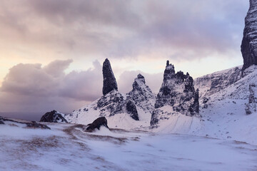 Old Man Storr, Isle Skye, Scotland. Winter, very snowy mountain in a very powerful sunrise. first morning lights among the clouds