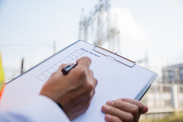 Engineer inspection high voltage tower record on check list, Engineer inspection power plant