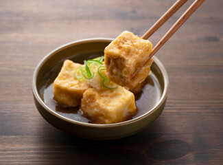 Deep-fried tofu on a wooden table.