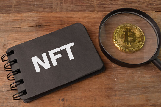 Golden bitcoin and notebook written with NFT stand for NON FUNGIBLE TOKENS