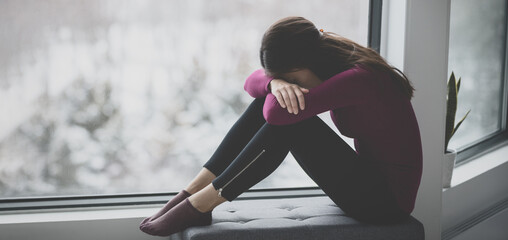 Sad crying young woman hiding face in sadness alone at home in isolation. Mental health problem...