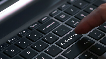 CONTACT US word on laptop keyboard button.