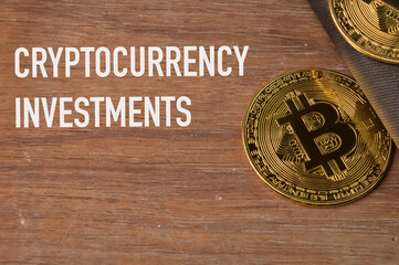 Golden bitcoin over wooden background written with CRYPTOCURRENCY BACKGROUND.
